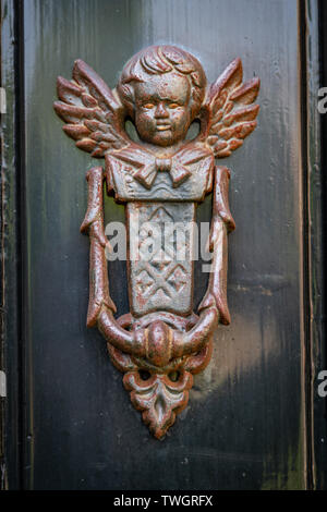 Old rusted door knocker with an angel with two wings in Haarlem in the Netherlands Stock Photo