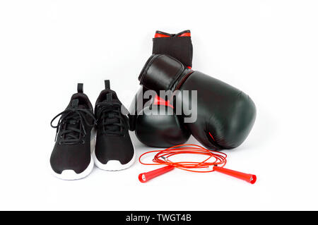 Black sports running shoes, boxing gloves and red jumping rope isolated on white background. Concept of fitness and healthy lifestyle Stock Photo