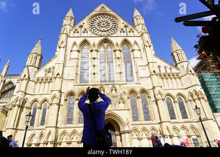 Male tourist taking a photograph of the south transept of York Minster from the street, York, North Yorkshire, England, UK. Stock Photo