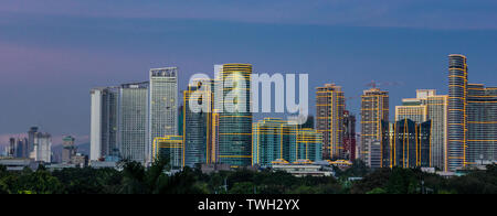 Skyscrapers in Bonifacio Global City (BGC) light up early evening in Metro Manila, Philippines, Stock Photo