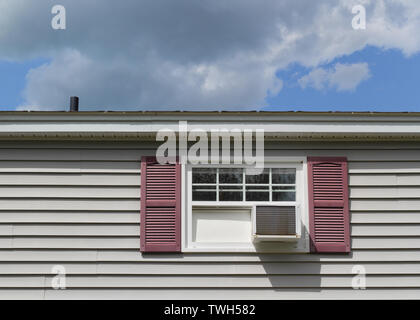 Air conditioner in house window on Summer day. Stock Photo