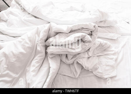 Crumpled Blanket and Sheet on the Bed in the Morning as Background in Hotel Stock Photo