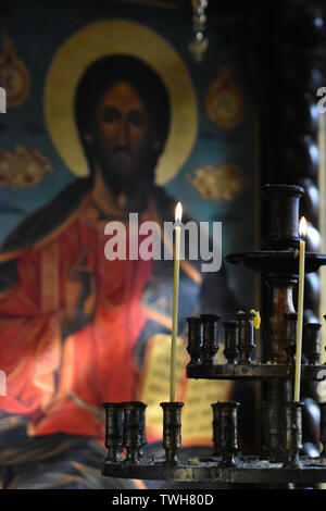 Candles burning in front of an icon of Jesus Christ in an orthodox church in Bulgaria Stock Photo