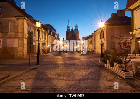 Gniezno in Poland, evening view of street in Old Town with The Royal Gniezno Cathedral in the background. Stock Photo