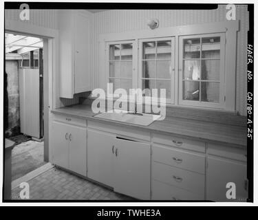 SECOND FLOOR EAST SIDE APARTMENT KITCHEN INTERIOR SHOWING GROUP OF THREE 6-LIGHT WOOD-FRAME CASEMENT WINDOWS OVER THE SINK, AND OPEN DOORWAY TO TOP OF EXTERIOR STAIR LANDING AND WALKWAY AT REAR OF HOUSE. WALKWAY IS VISIBLE THROUGH KITCHEN WINDOWS. VIEW TO SOUTH. - Lee Vining Creek Hydroelectric System, Triplex Cottage, Lee Vining Creek, Lee Vining, Mono County, CA Stock Photo