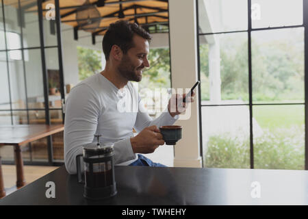 Man with coffee cup using mobile phone Stock Photo