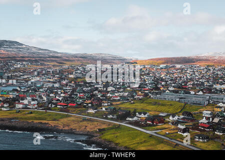 Aerial shot of the town Torshavn as taken during a helicopter flight on an early spring morning with snow-covered mountains (Faroe Islands, Denmark) Stock Photo