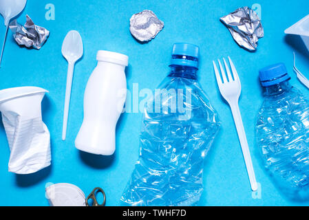 Plastic trash on blue background, eco concept image. Stock Photo