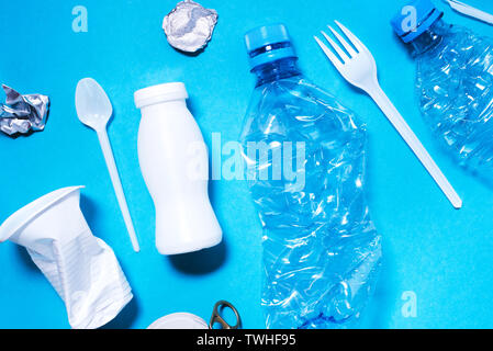 Plastic trash on blue background, eco concept image. Stock Photo