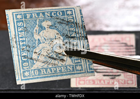 Swiss 10 Rappen Strubel stamp held by tweezers. Stock Photo