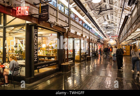 USA, New York. May 4, 2019. Chelsea market. Interior view of the entrance hall, people walking, illuminated stores