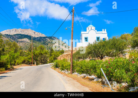 White typical church along road on Karpathos island, Greece Stock Photo