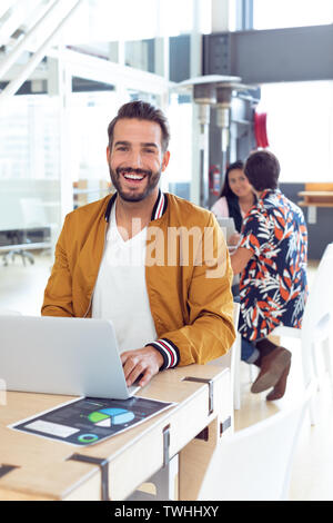 Businessman using laptop on desk in the office Stock Photo