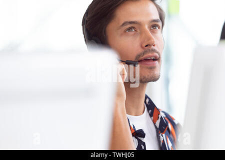 Male customer service executive working on computer at desk Stock Photo