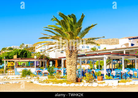 Traditional Greek taverna restaurant on coast of Karpathos island in Ammopi village, Greece Stock Photo