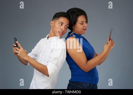 Young people with smartphones on gray studio background Stock Photo