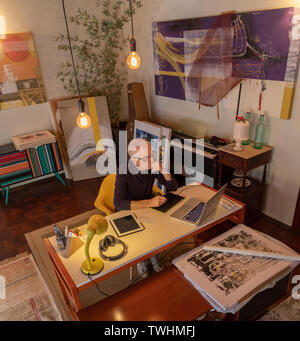 Middle aged man using computer in his art studio and drawing on his tablet Stock Photo