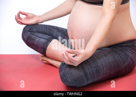 Future Young mother exercise yoga. Beautiful Pregnant Woman meditate Stock Photo