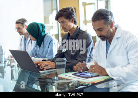 Medical team working together at table in hospital Stock Photo