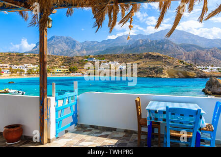 Terrace with table in traditional Greek tavern in Lefkos port on Karpathos island, Greece Stock Photo