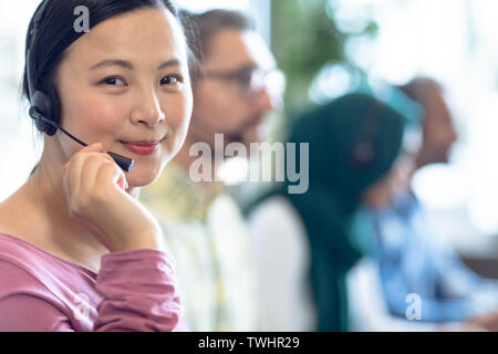 Female customer service executives talking on headset at desk Stock Photo