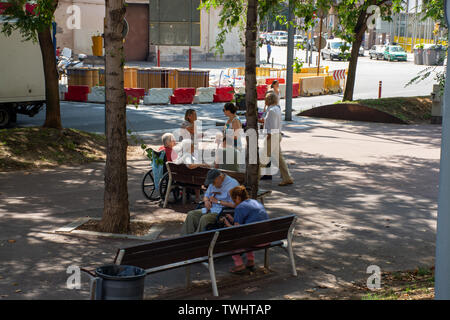 Barcelona, Spain - 27th July 2017 - Elderly people sitting on bench sleeping talking Stock Photo