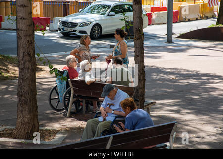 Barcelona, Spain - 27th July 2017 - Elderly people sitting on bench sleeping talking Stock Photo