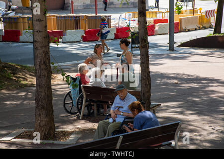 Barcelona, Spain - 27th July 2017 - Elderly people sitting on bench sleeping talking Stock Photo