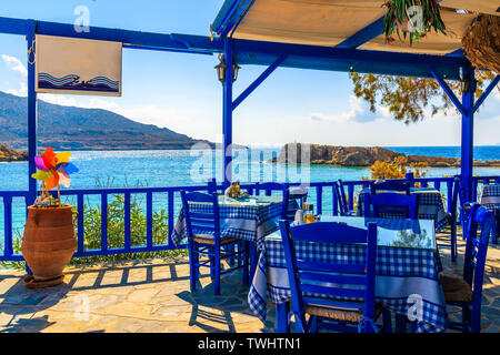 Terrace with tables in traditional Greek tavern with sea view in Lefkos village on Karpathos island, Greece Stock Photo