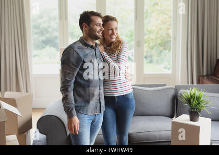 Happy beautiful couple looking away in new home Stock Photo