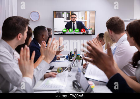 Group Of Businesspeople Having Video Conference With Another Business Team In Office Stock Photo