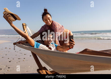 Young couple taking selfie with mobile phone on the beach Stock Photo