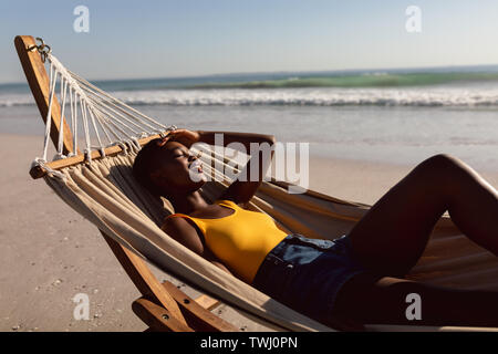 Woman relaxing in a hammock on the beach Stock Photo