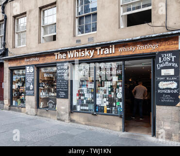 Entrance and frontage of The Whisky Trail, a shop selling a wide variety of Scotch whiskies in  the Royal Mile / High Street of Edinburgh, Scotland. Stock Photo