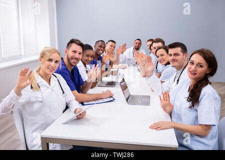 Group Of Happy Doctors Waving Their Hands At Medical Conference Stock Photo