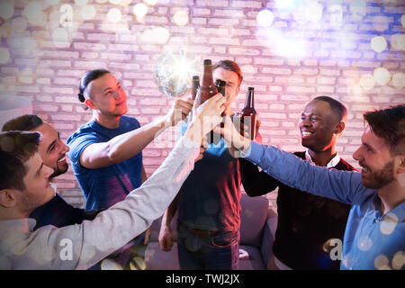 High Angle View Of Multiracial Friends  Clenching Beer Bottles At Disco Bar Stock Photo