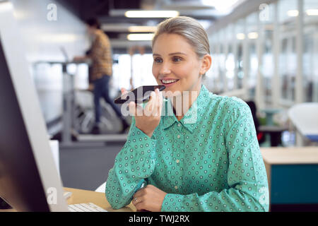 Female graphic designer talking on mobile phone Stock Photo