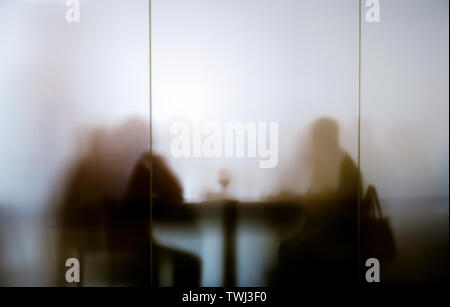 Silhouttes seated at table eating lunch Stock Photo
