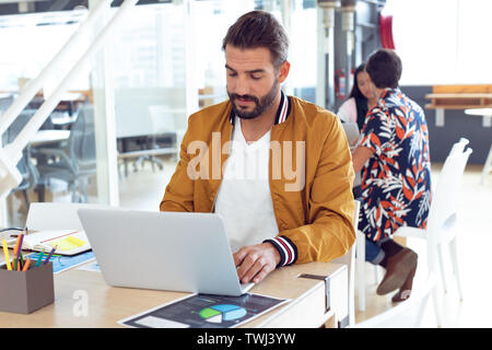 Businessman using laptop on desk in the office Stock Photo