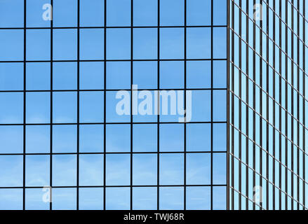 Corner of office building windows in square grid pattern reflecting sky. Stock Photo