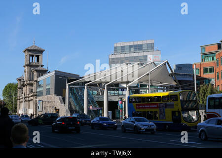 Summer evening traffic in Dublin on Amiens Street passing Connolly train station and Connolly Luas halt Stock Photo