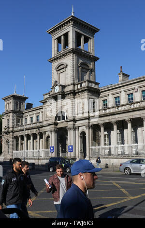 Summer evening with blue sky in Dublin with people crossing a Dublin Street in front of Connolly railway station in Amiens Street, Dublin. Ireland. Stock Photo