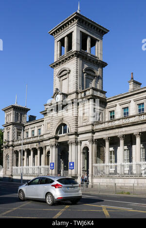 The original stone façade of Connolly station Dublin on a sunny evening with a car and people walking past on Amiens Street. Stock Photo