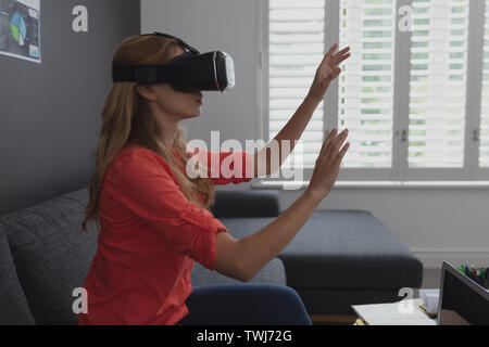 Female executive using virtual reality headset Stock Photo