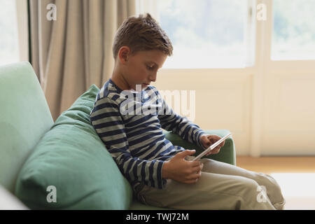 Boy using digital tablet on sofa in a comfortable home Stock Photo