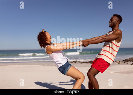 Couple having fun on beach in the sunshine Stock Photo
