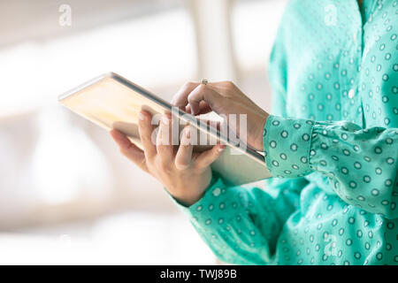 Businesswoman using digital tablet in office Stock Photo