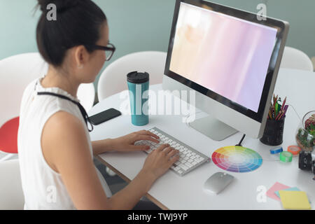 Female graphic designer working on computer at desk in a modern office Stock Photo