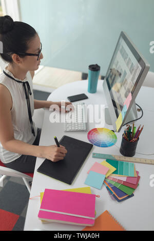 Female graphic designer using graphic tablet at desk in a modern office Stock Photo