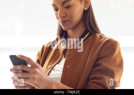 Businesswoman using mobile phone in a modern office Stock Photo